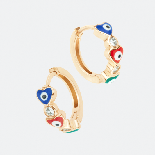 The corazones hoop earring by Ocarina, an 18K gold-plated design featuring colorful enamel heart-shaped evil eyes and sparkling zircon stones. A playful and symbolic jewelry piece for protection and love, displayed against a clean white background