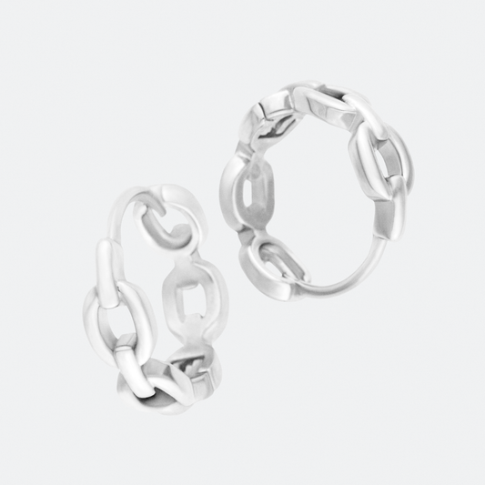 The Catena hoop earrings by Ocarina, bold silver earrings featuring an interlocking chain-link design. A modern and edgy statement piece that blends industrial aesthetics with elegance, displayed against a clean white background