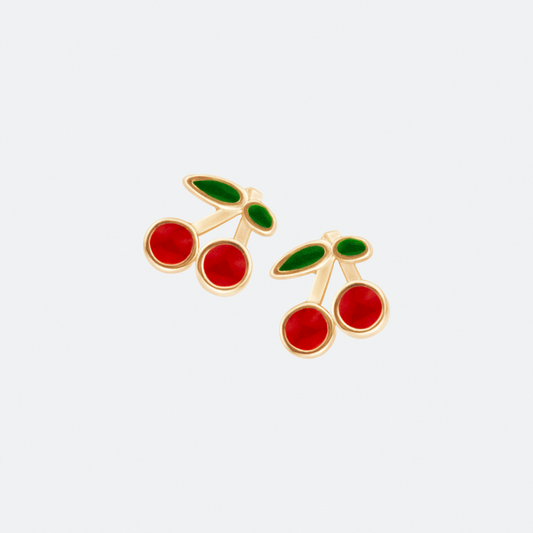 The Cereza earrings by Ocarina, playful gold-plated stud earrings featuring a cherry design with vibrant red and green enamel detailing. A fun and nostalgic jewelry piece inspired by retro aesthetics, displayed against a clean white background